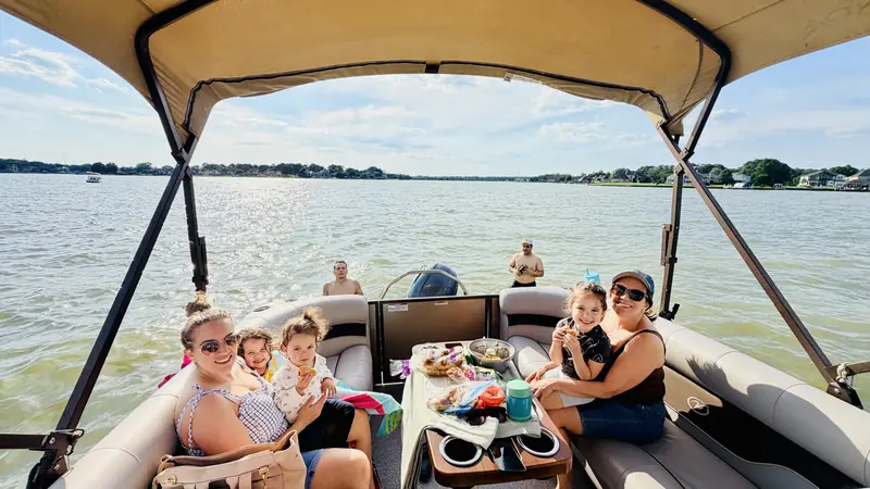 Family enjoying snacks on the Veranda V22RC pontoon under the shaded top on Lake Conroe